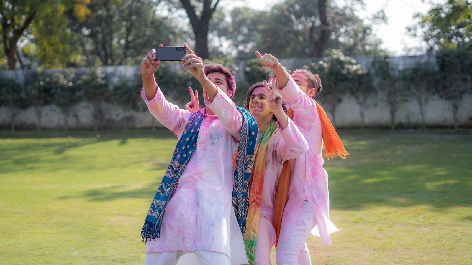 Group of friends taking a selfie covered in Holi colors