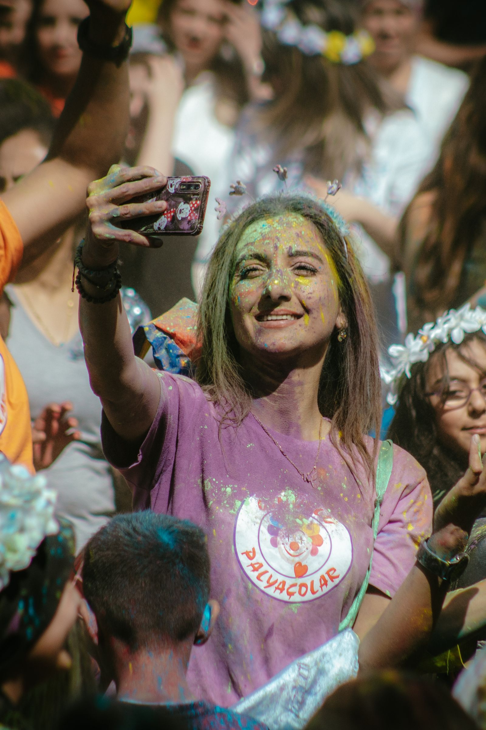 Guest taking a selfie covered in Holi colors for face matching
